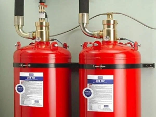 Two red fire suppression cylinders with brass valves and discharge hoses
