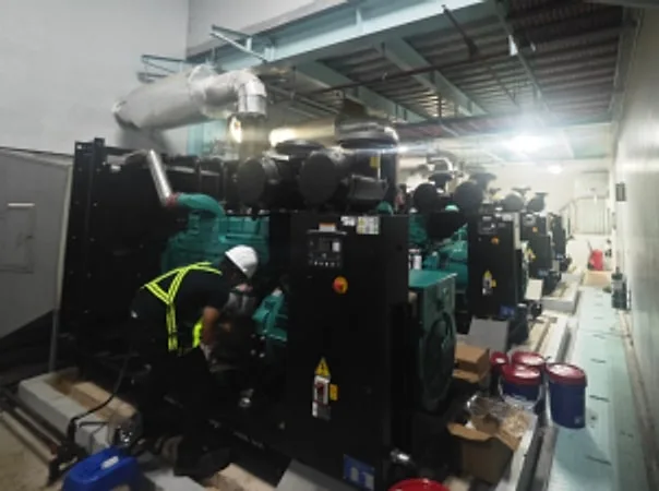 Technician working on large black generator sets in a generator room