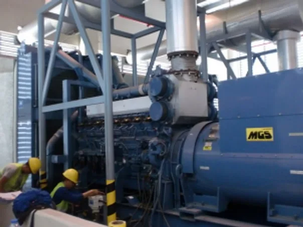 Technicians working beside a large blue generator set
